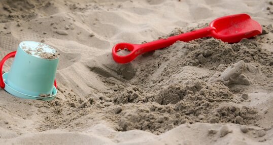 Sandkasten mit Schaufel und Eimer