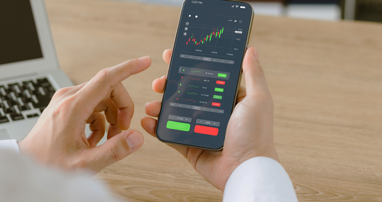 Businessmen work with stock market investments using smartphones to analyze trading data. smartphone with stock exchange graph on screen. Financial stock market