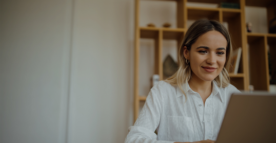 Young beautiful woman working on laptop at home office, copy space, portrait.