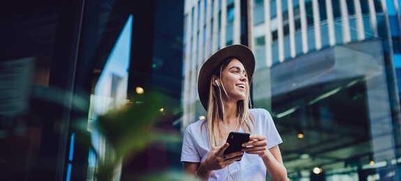 Cheerful woman listening to music in cafe