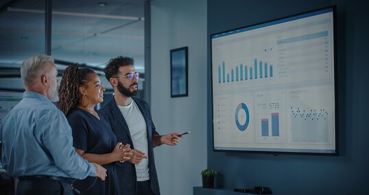 Company Operations Manager Holds Meeting Presentation. Diverse Team Uses TV Screen with Growth Analysis, Charts, Statistics and Data. People Work in Business Office.