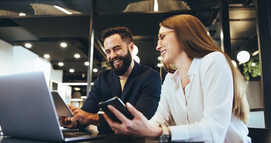 Smiling entrepreneurs using wireless technology together