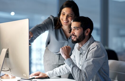 Call center, manager and telemarketing team at computer for software training, customer service and CRM in office at night. Man, woman and sales mentor helping intern on desktop for technical support