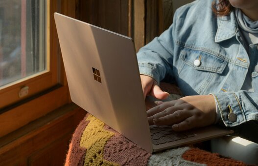 Eine Frau, die mit einem Laptop auf einem Stuhl sitzt