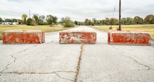 Rote Zementblöcke, die auf einer Straße eine Barriere bilden.