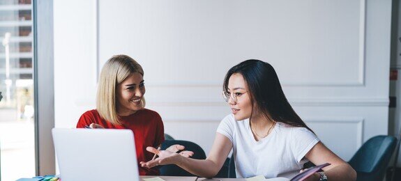 Multiethnic women working with laptop in office