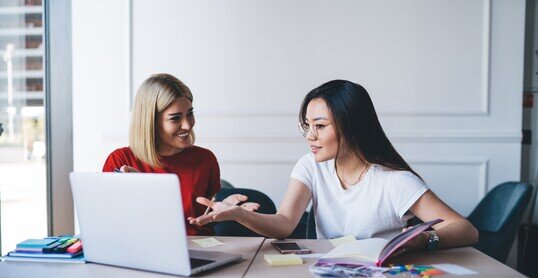 Multiethnic women working with laptop in office