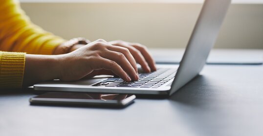 Close up of female hands while typing on laptop