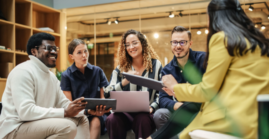 Multiethnic Group of People Meeting and Discussing Innovative Ideas in a Casual Conference Room in the Office. Smiling Colleagues Putting Together a Presentation