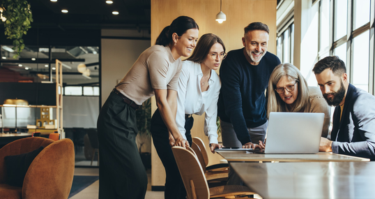 Group of businesspeople using a laptop together