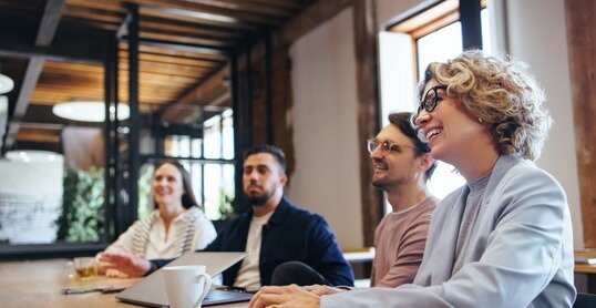 Conference meeting in an office, happy business team sits together in a boardroom