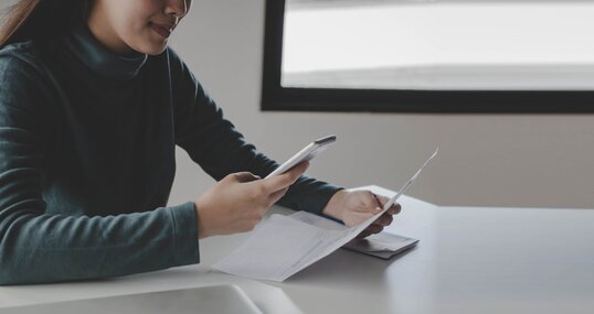 panoramic banner. young woman using mobile smart phone for scan and payment online with family budget cost bills on desk in home office, plan money cost saving, investment, finance, expenses concept