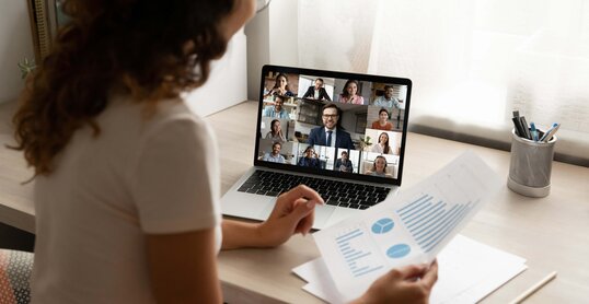 Foto einer Frau die auf einem Laptop schaut auf dem ein Video Call stattfindet