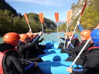 Mitarbeitende der novaCapta in einem Schlauchboot auf einem Fluss in den Bergen beim Rafting