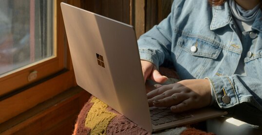 Eine Frau, die mit einem Laptop auf einem Stuhl sitzt