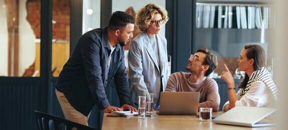 Gruppe von Geschäftsleuten in einer Besprechung vor einer SharePoint Site