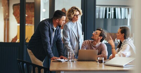 Gruppe von Geschäftsleuten in einer Besprechung vor einer SharePoint Site