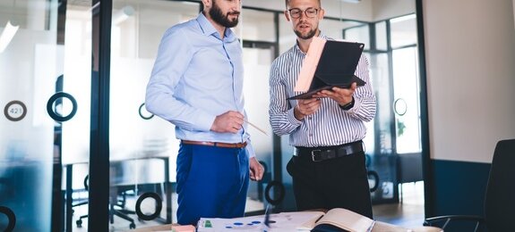 AdobeStock, zwei Männer im Büro im Austausch