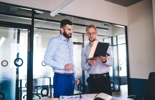 AdobeStock, zwei Männer im Büro im Austausch