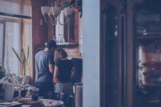 Two people standing in the kitchen